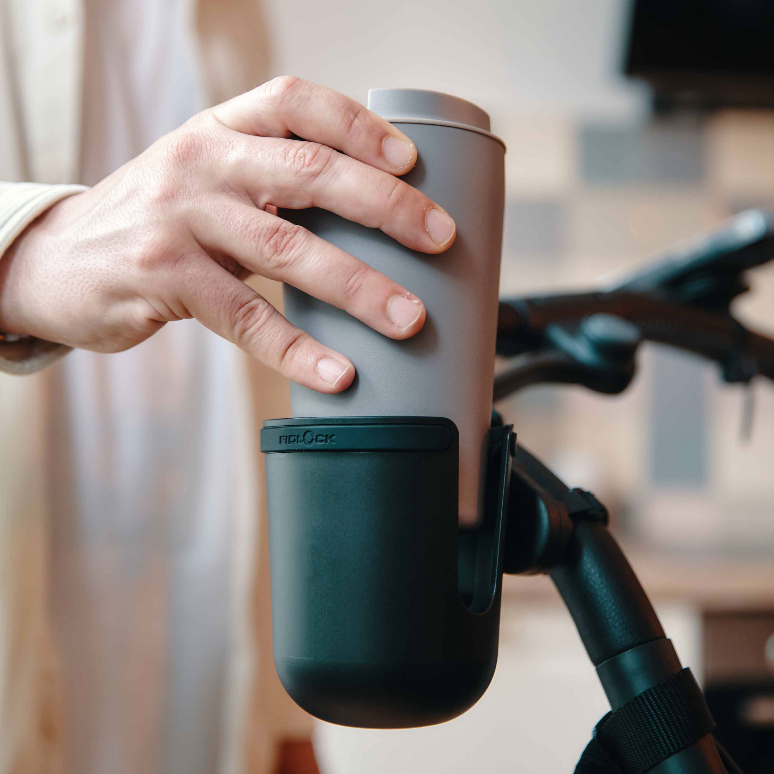 FIDLOCK_TWIST_cup-holder_mit-stroller-base-und-Kaffee-Becher_reinstellen_am-tfk