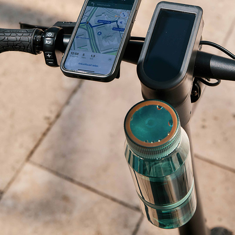 FIDLOCK-Webseite-TWIST-bottle-700-life-grün-mit-bike-base-am-E-scooter-und-Handy