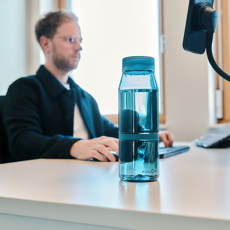 FIDLOCK-Webseite-TWIST-bottle-700-life-blau-stehend-auf-dem-Schreibtisch