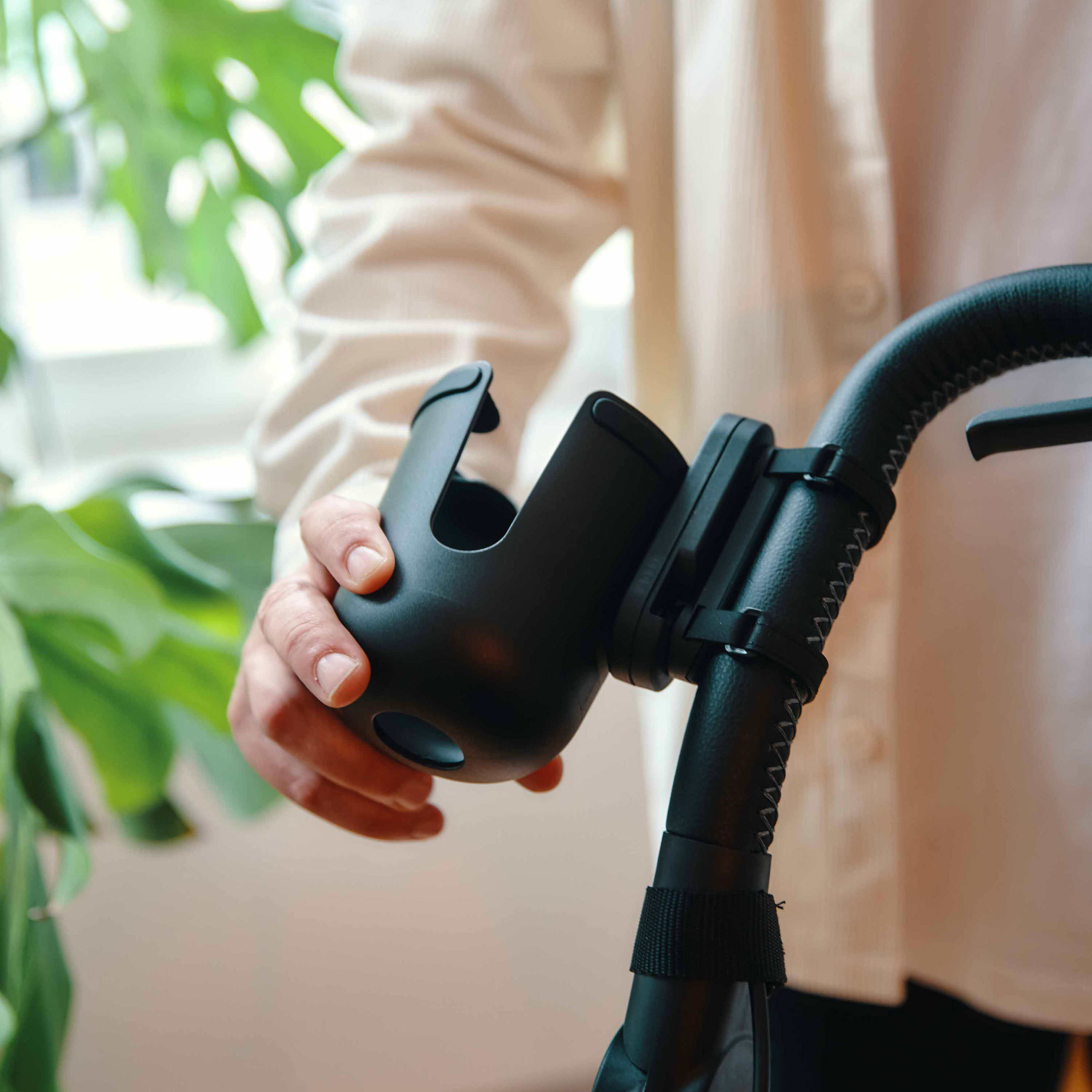 FIDLOCK_TWIST_cup holder-am-Kinderwagen-befestigt-mit-Hand-zum-verstellen-seitlich
