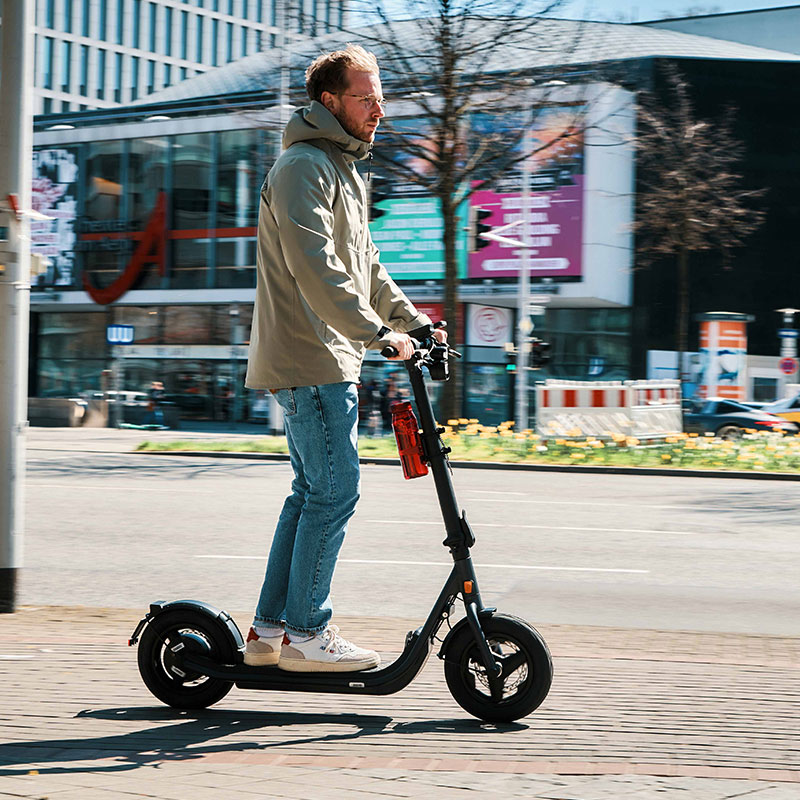 FIDLOCK-Webseite-Aktivitäten-E-Scooter-TWIST-uni-base-und-bottle-700-life-rot-fahrend